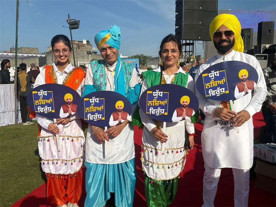 Folk performers in traditional dress holding Yudh Nashian Virudh anti-drug placards at the marathon